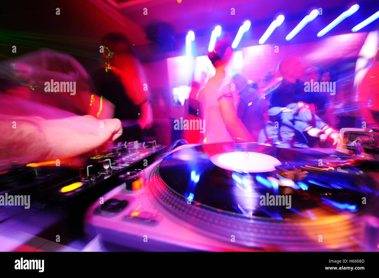 DJ behind the decks in a nightclub. Stock Photo