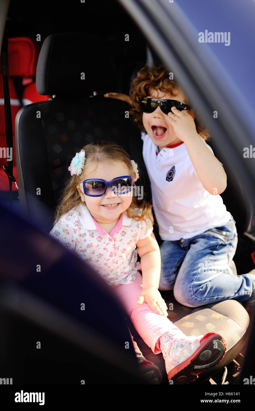 children sit in the car and play Stock Photo