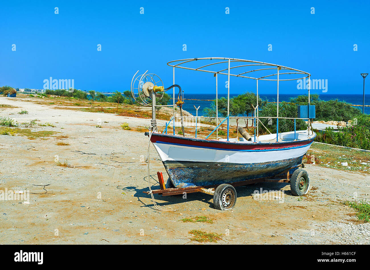 The old boat like the symbol of the fishing village welcomes tourists, coming to Zugi, Cyprus. Stock Photo