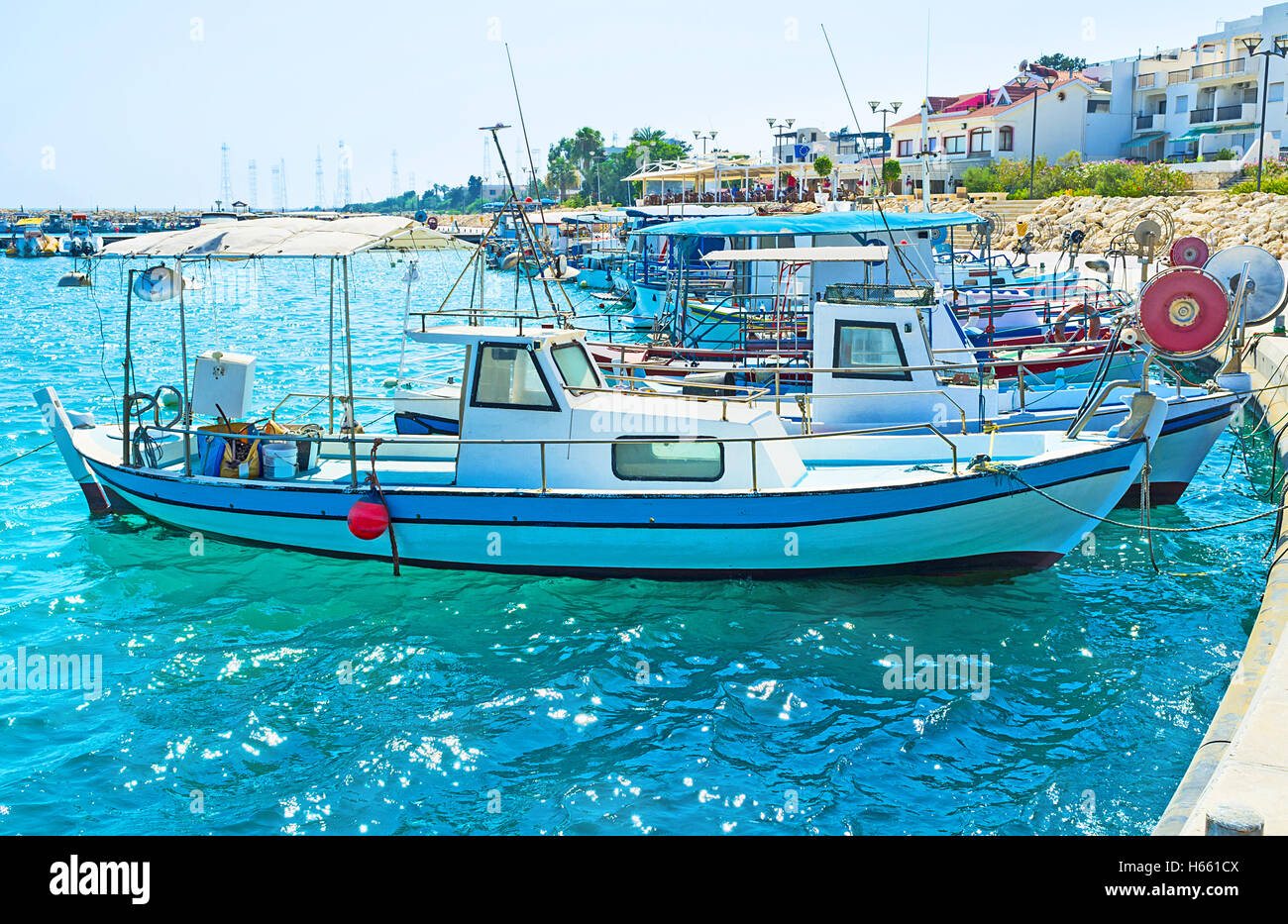 The old fishing boats are waving on the waves in the small port of Zugi village, Cyprus. Stock Photo