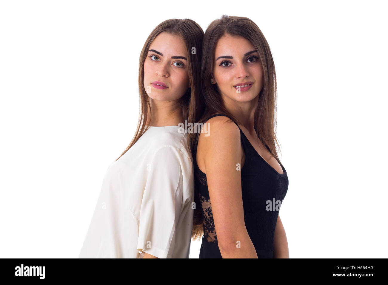 Two young woman standing back to back Stock Photo