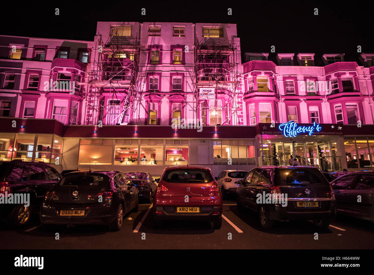 Brightly lit, magenta pink hotel in Blackpool, England during autumn while the famous Black Illuminations are lit up Stock Photo