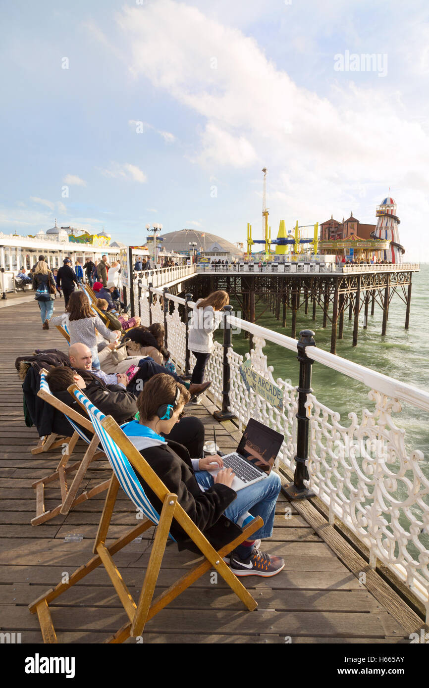 People enjoying themselves on Brighton Pier; East Pier, Brighton, East Sussex, England UK Stock Photo