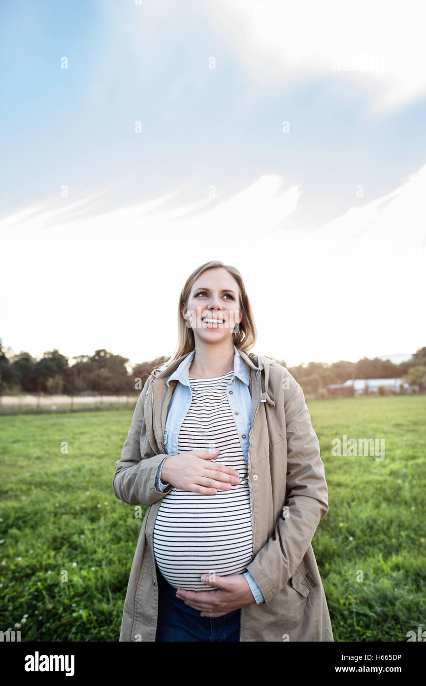 Beautiful pregnant woman on a walk in green sunny nature Stock Photo ...