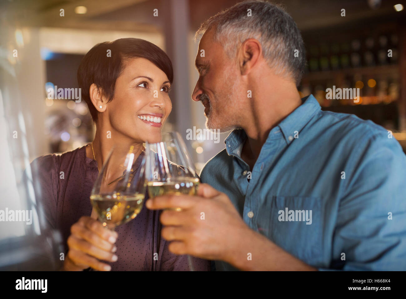 Couple toasting white wine glasses in restaurant Stock Photo Alamy