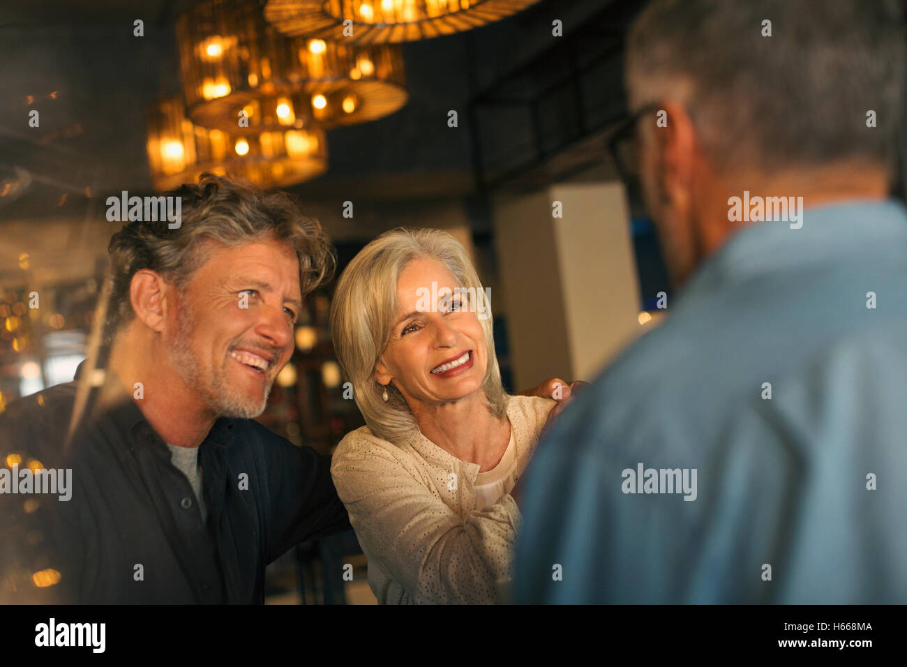 Smiling friends talking in restaurant Stock Photo