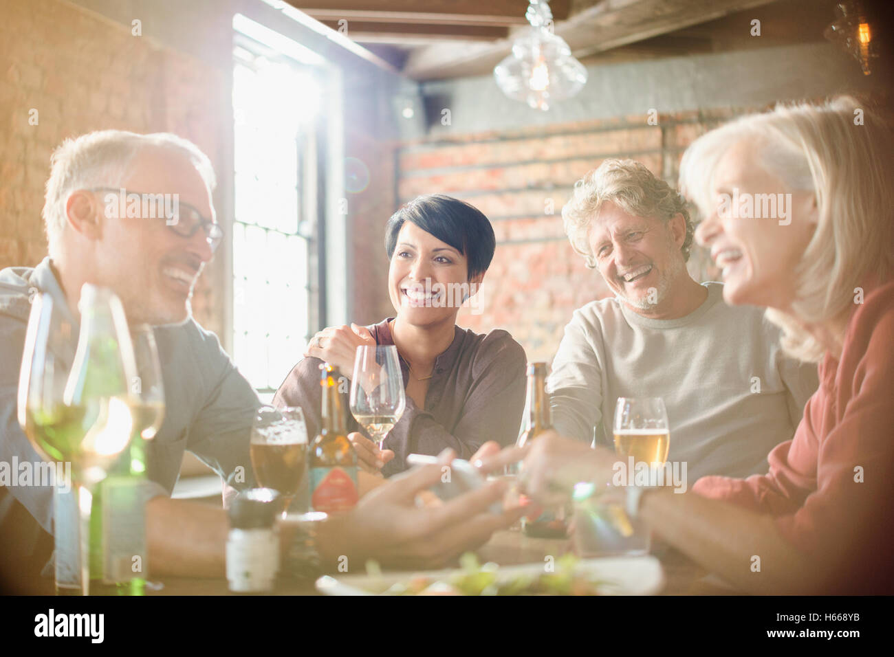 Couples dining and using cell phone at restaurant table Stock Photo