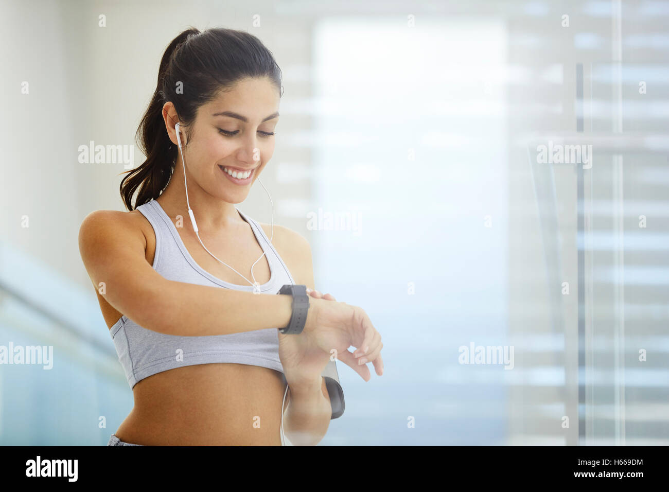 Woman exercising with headphones checking smart watch Stock Photo