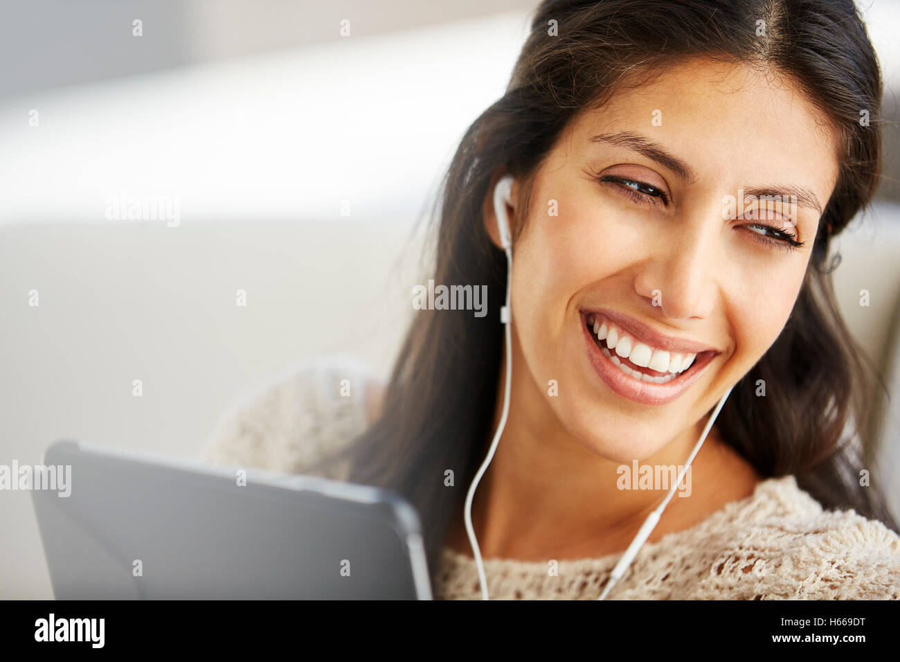 Close up smiling woman using digital tablet with headphones Stock Photo