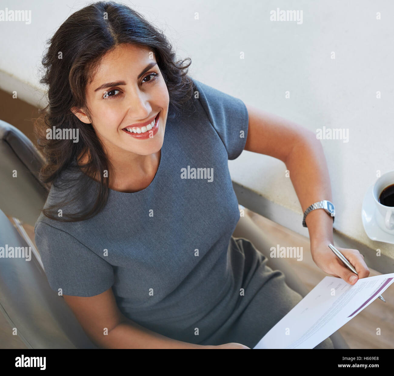 Portrait smiling businesswoman reviewing paperwork Stock Photo - Alamy