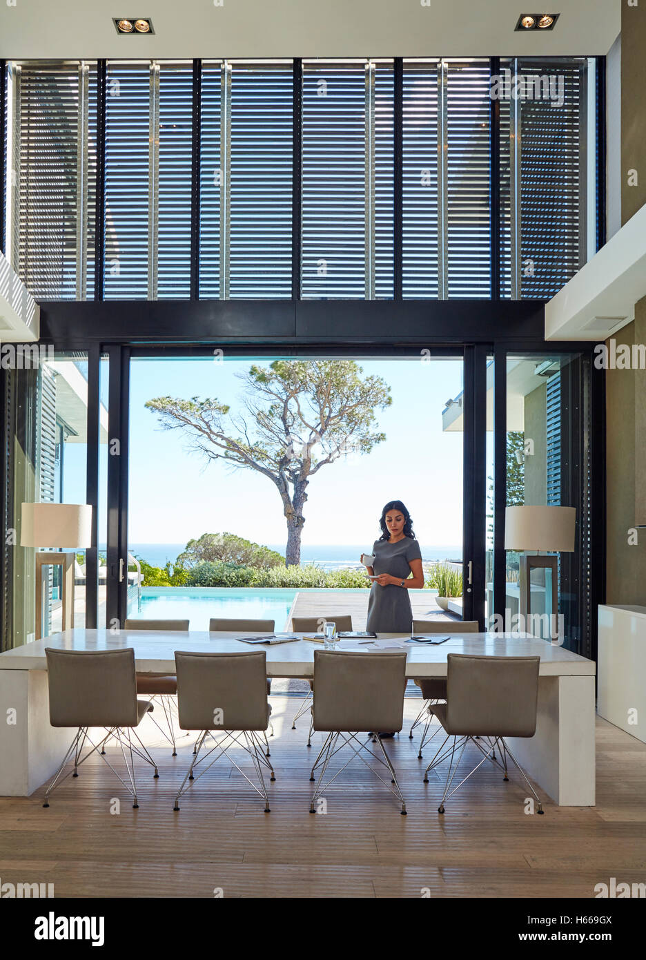 Businesswoman working at dining table in luxury home showcase interior