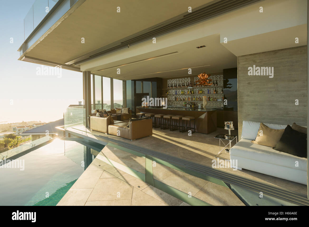Sunny luxury home showcase exterior patio with infinity pool Stock ...