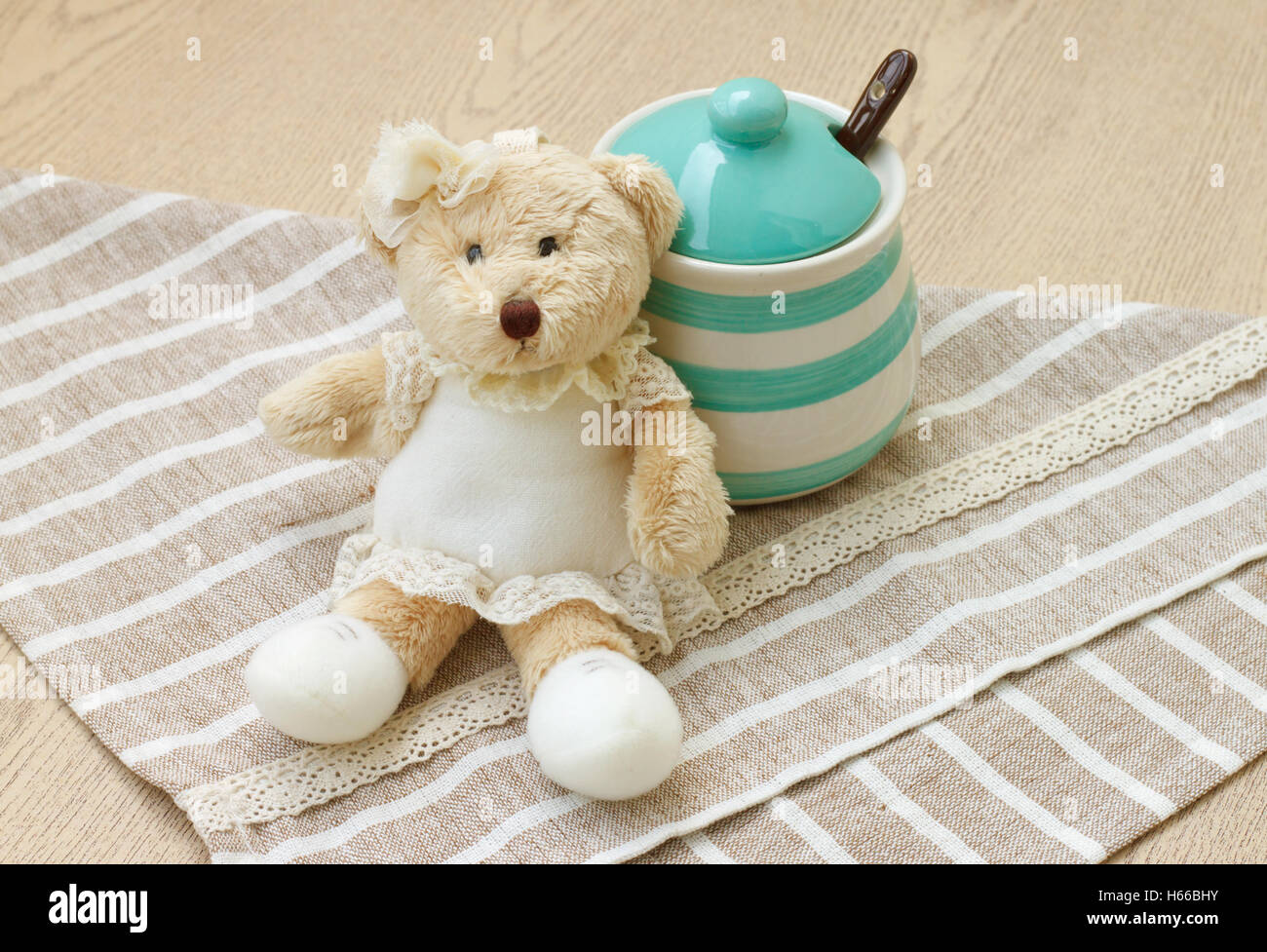 Green pastel porcelain jar and little bear doll with cute fabric. Stock Photo
