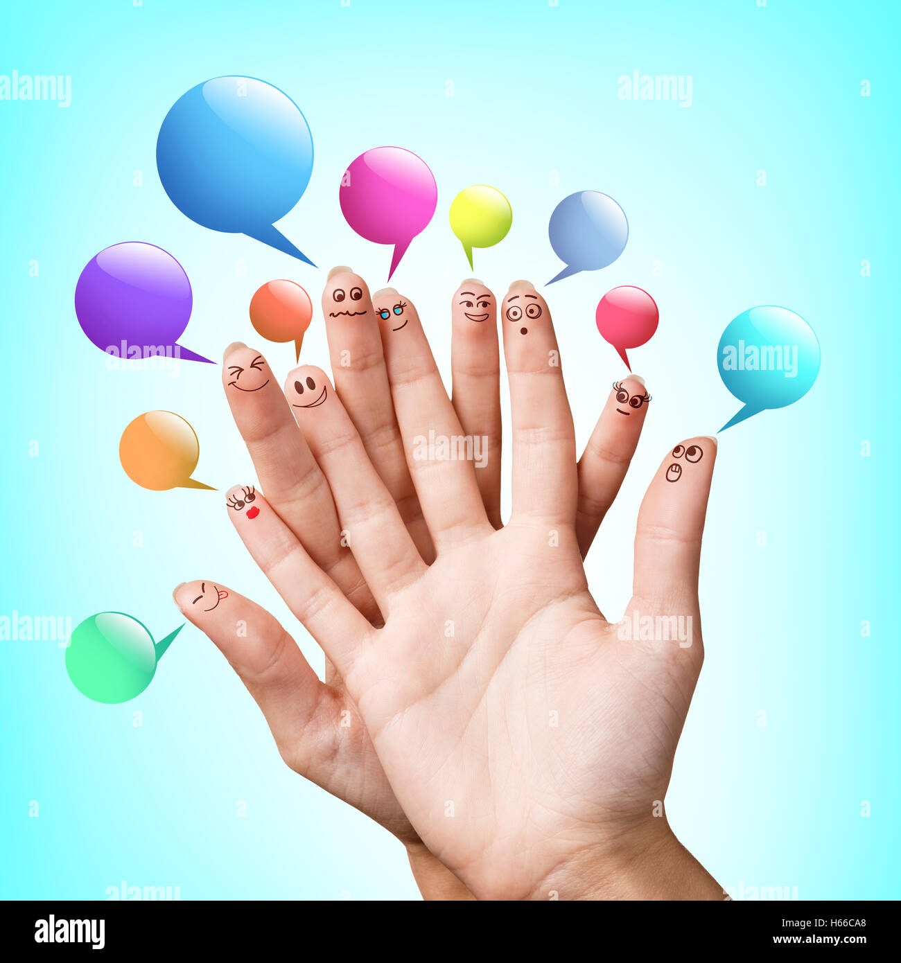 Happy finger smileys with colorful speech bubbles over blue background Stock Photo