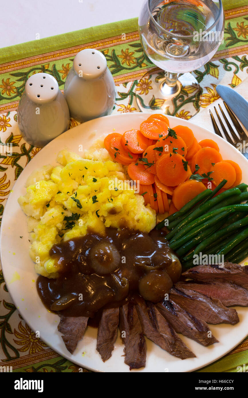 A dish of Seared Venison Steak with mash potato green bean, carrots and