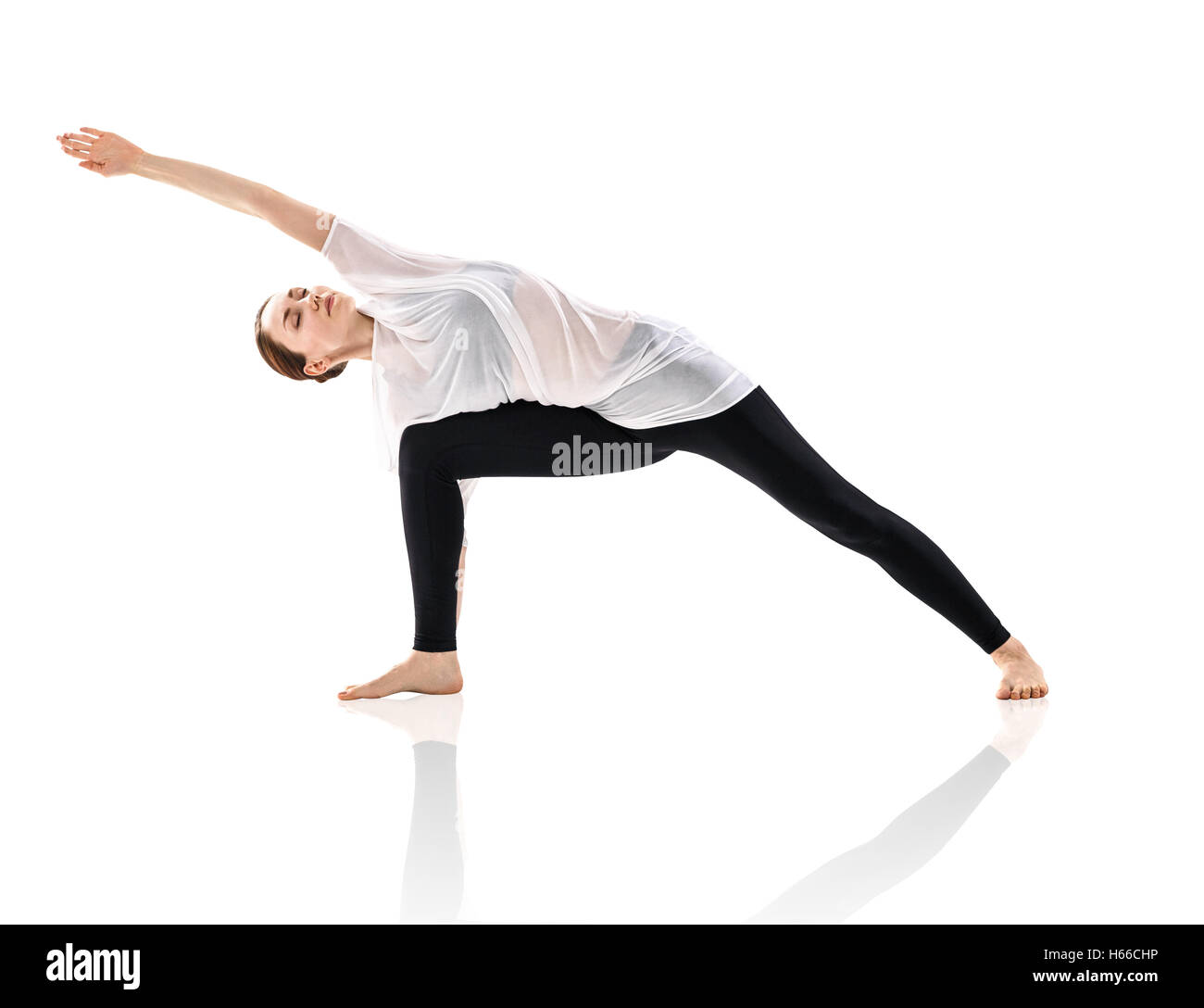 Young woman doing yoga exercise in the white room Stock Photo