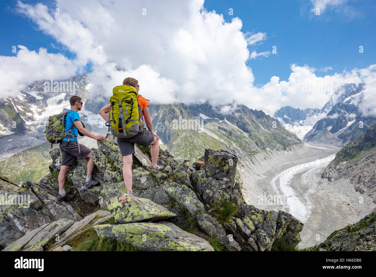 Hikers looking across Mer de Glace glacier from Signal Forbes, Montenvers. Chamonix Valley, French Alps, France. Stock Photo