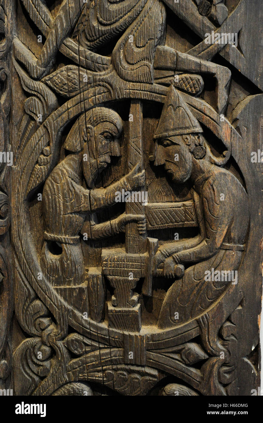 Norway. Setesdal. Hylestad church. Stave-church portal.  c. 1200. Carved on the panels are scenes from the 'Sigurd Favnesbane' stories. Relief carving in wood and depicting the sword Gram finished which is tried on the anvil and it breaks. Historical Museum. Oslo. Norway. Stock Photo