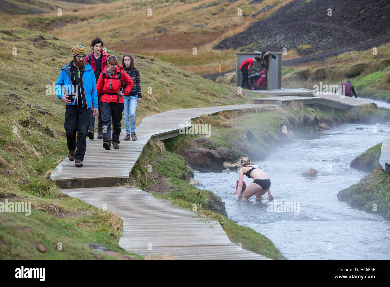 People bathe in the geotermally heated water of an Icelandic river at