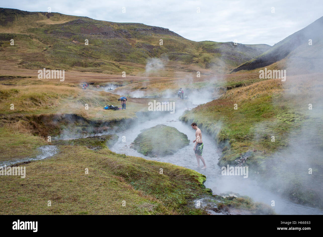 People bathe in the geotermally heated water of an Icelandic river at