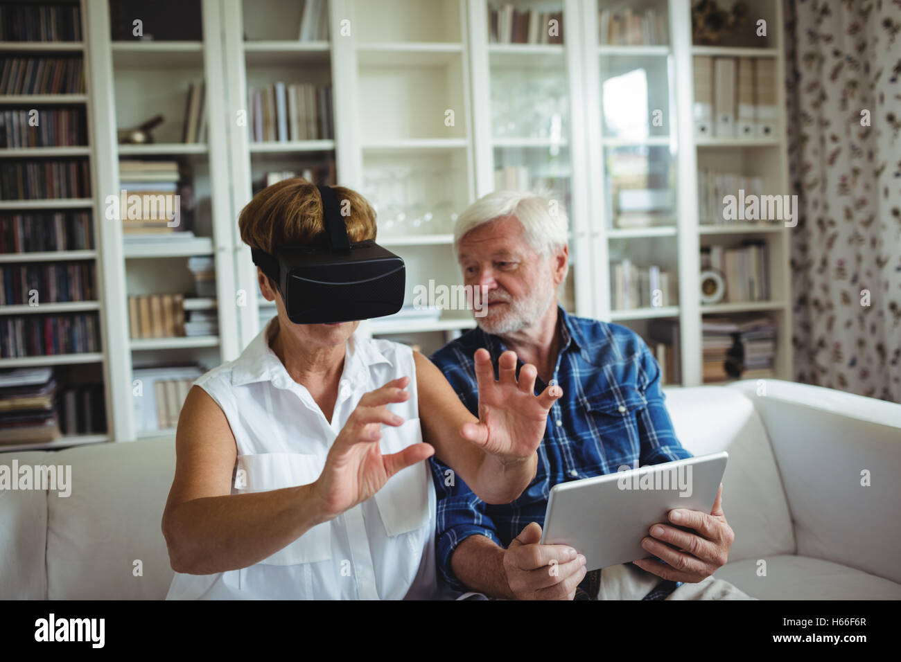 Senior couple using digital tablet and virtual reality headset Stock Photo