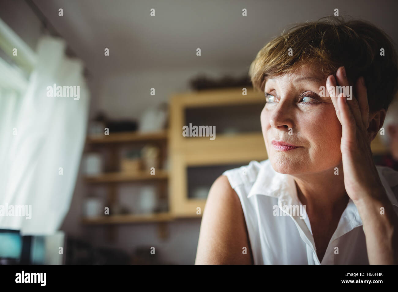 Worried senior woman with hand on forehead Stock Photo