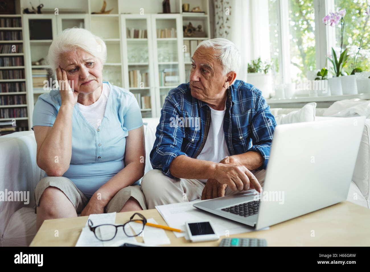 Worried senior couple using laptop Stock Photo