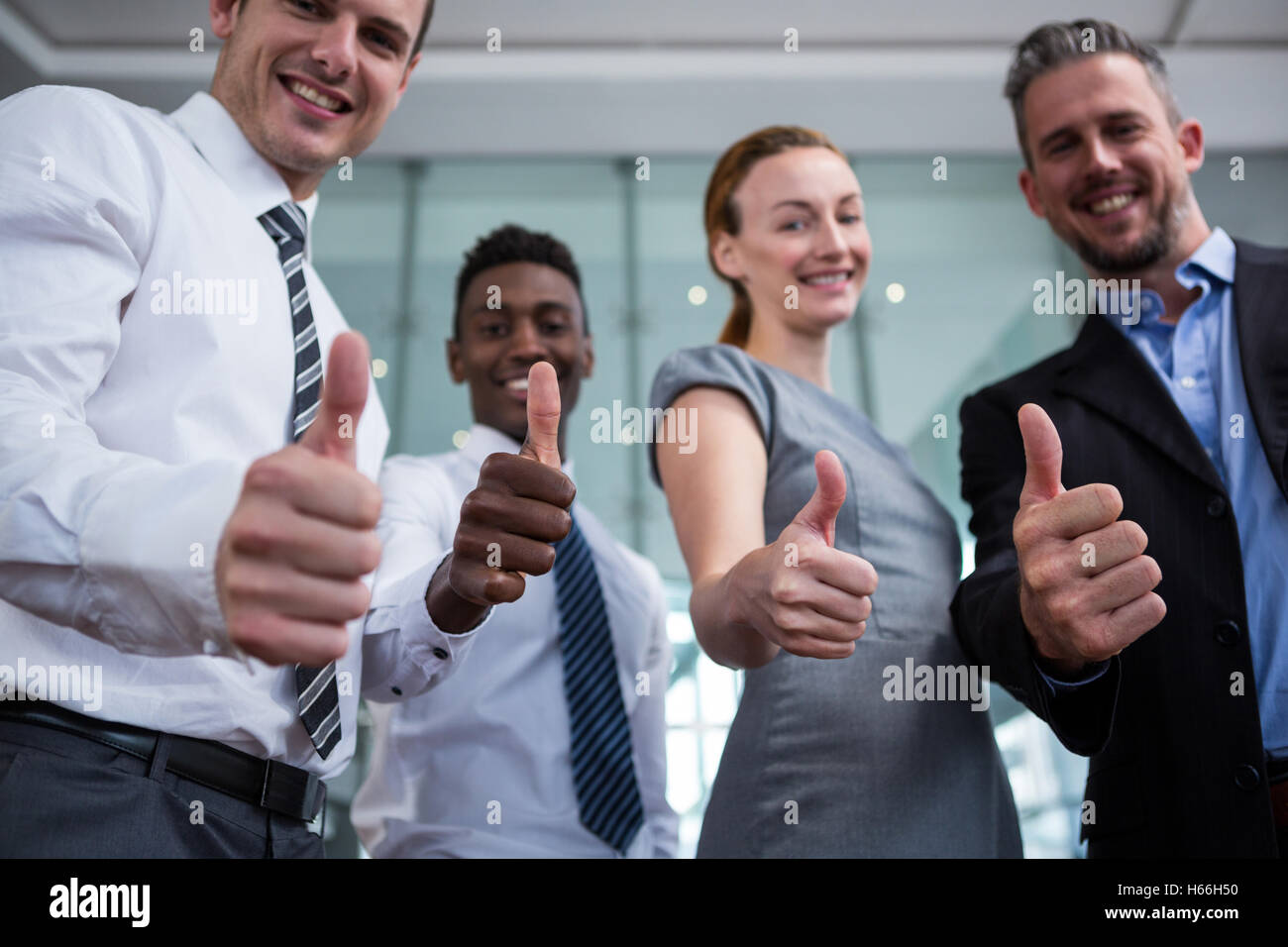 Business executive showing thumbs up in office Stock Photo