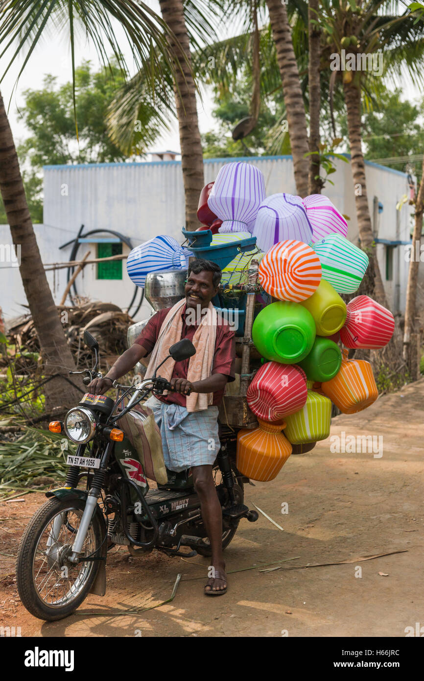Ambulant vendor on his motorcycle selling plastic jars. Stock Photo