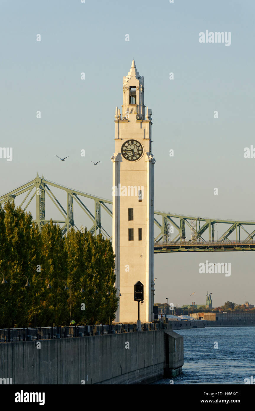 The Clock Tower located on Quai de Horloge with the Jacques Cartier Bridge in back, Old Port of Montreal, Quebec, Canada Stock Photo