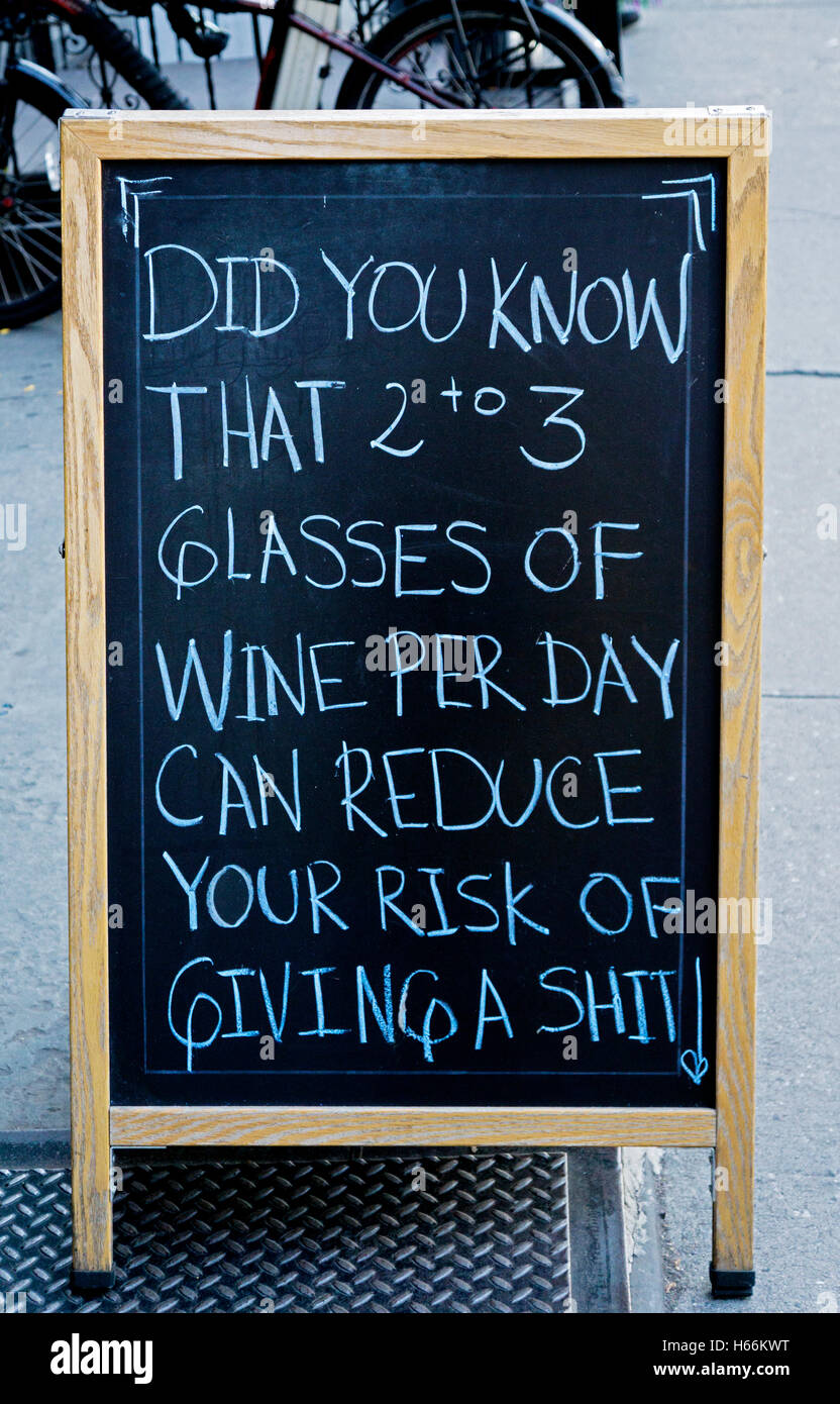 A funny sign outside of a liquor store on Ninth Avenue in Midtown Manhattan encouraging people to drink wine. Stock Photo