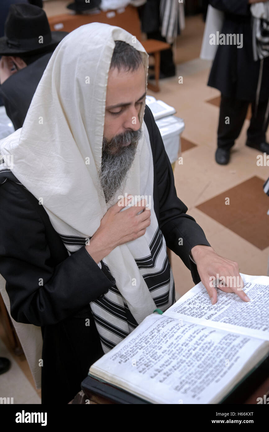 A religious Jewish man leading a group in prayers at a synagogue in Crown Heights, Brooklyn, New York Stock Photo