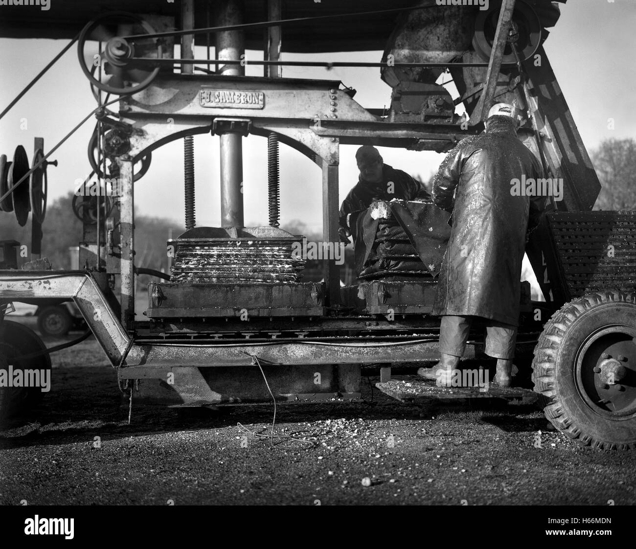 farmers pressing apples for juice and cider in Normandy cider making machine Stock Photo