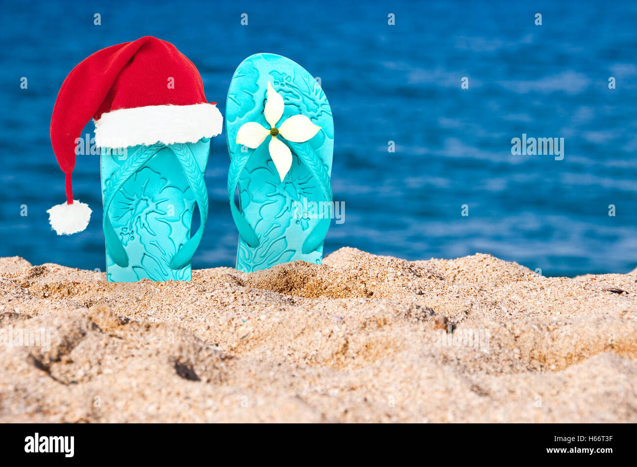 Christmas hat on flip flops in the sand of a beach Stock Photo