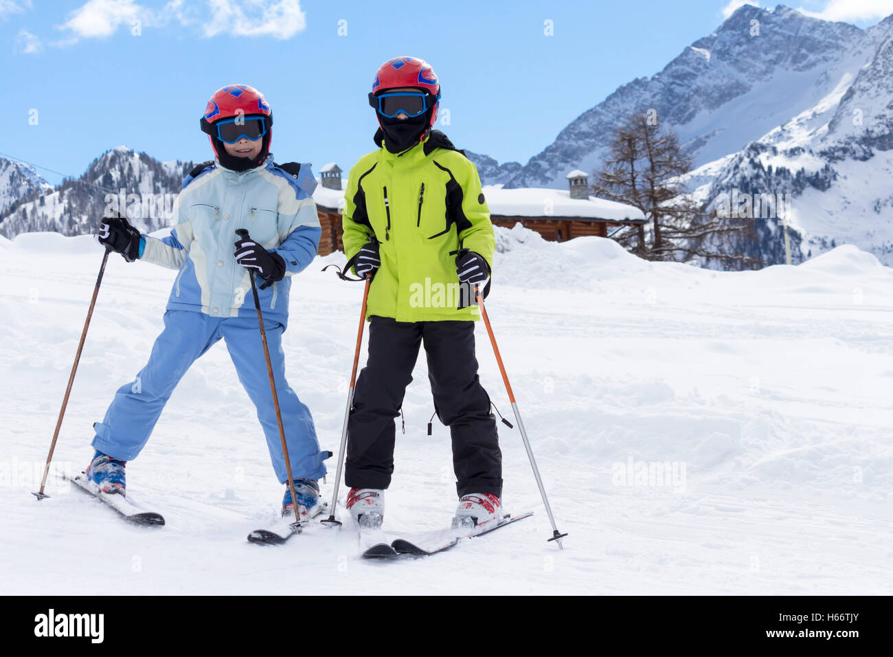 children on a ski slope with mountain background and snow Stock Photo
