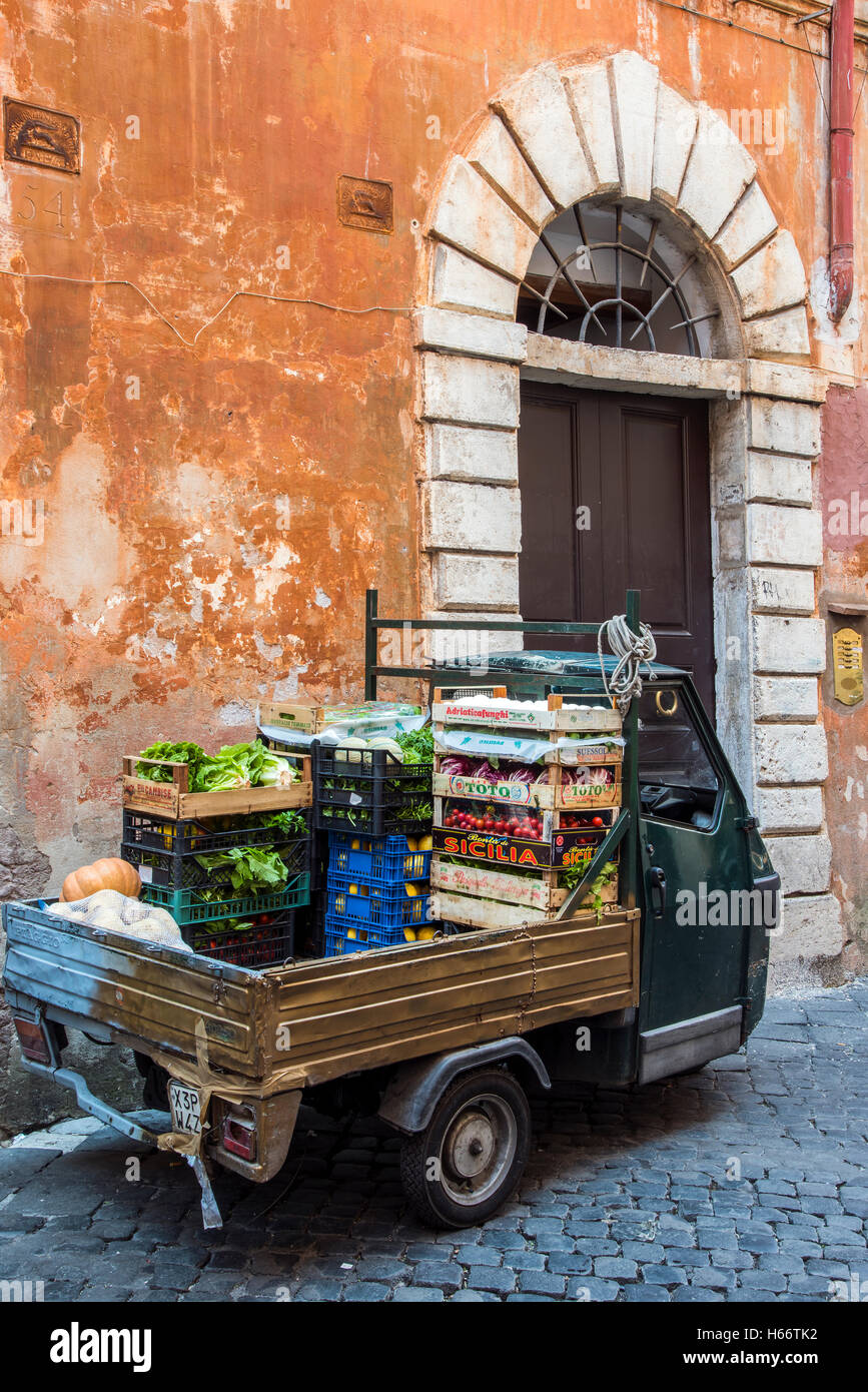 Old Piaggio Ape three-wheeled light commercial vehicle parked in a street of Rome, Lazio, Italy Stock Photo