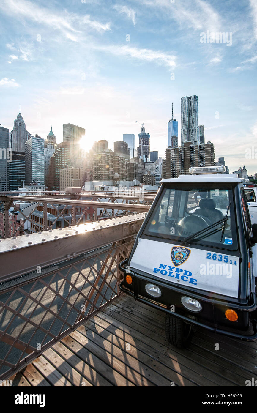 NYPD police vehicle on Brooklyn Bridge, East River, with view of Lower