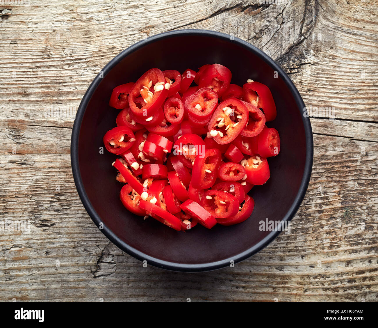 Bowl of red hot chili pepper on wooden table, top view Stock Photo