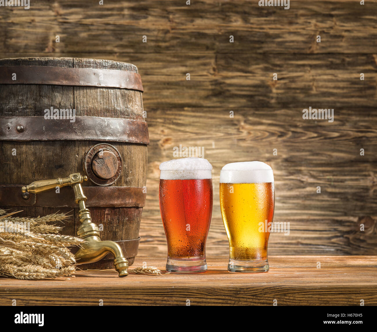 Glasses of  beer and ale barrel on the wooden table. Craft brewery. Stock Photo