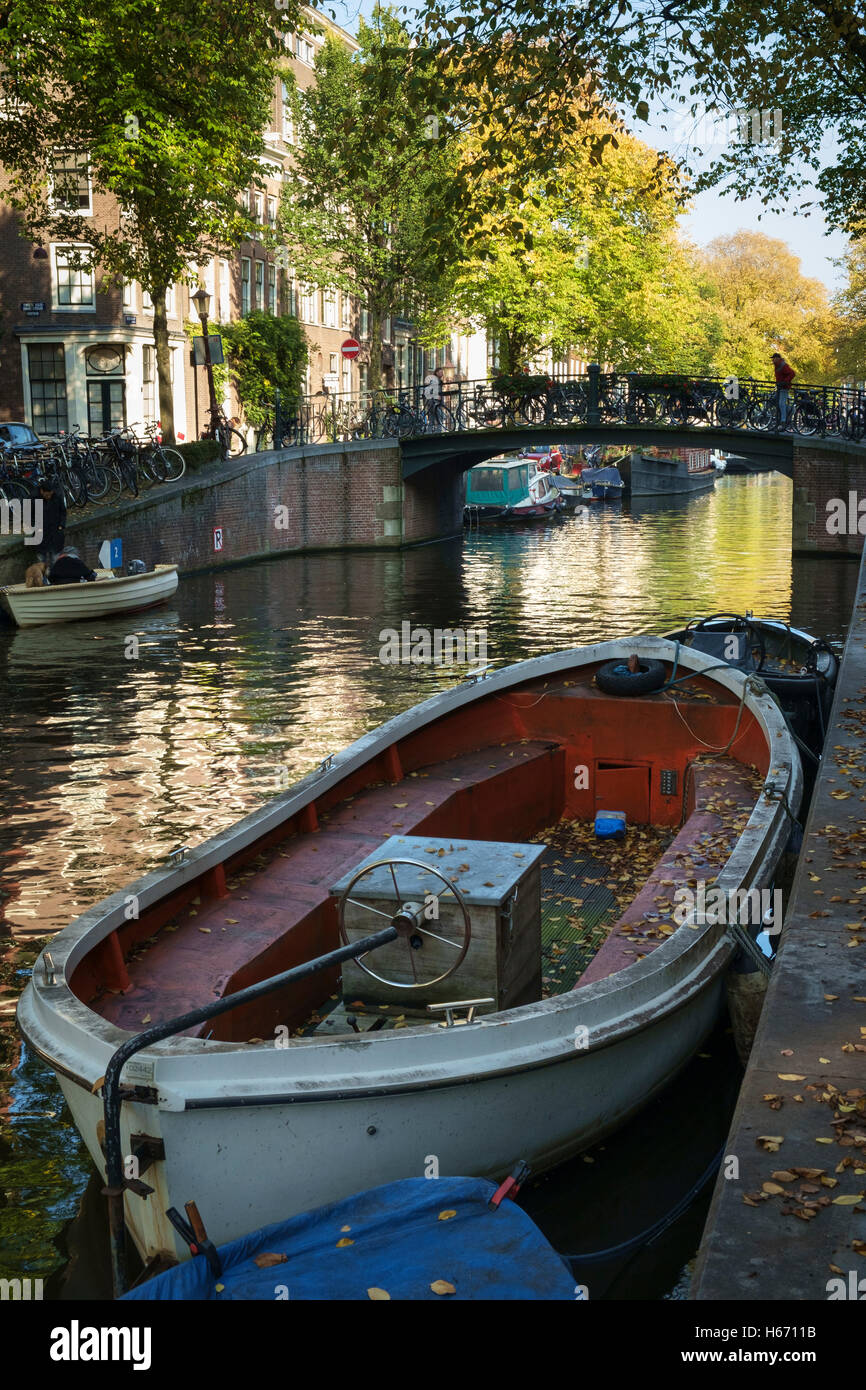 Autumn leaves fallen on a moored boat on an Amsterdam canal. Stock Photo