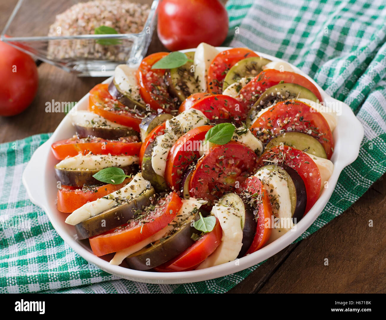 Prepared gratin dish raw eggplant with mozzarella and tomatoes Stock Photo