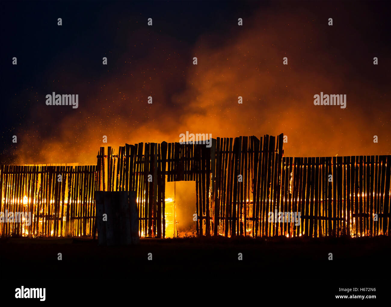 Wooden structure on fire with small sparks flying around. Stock Photo