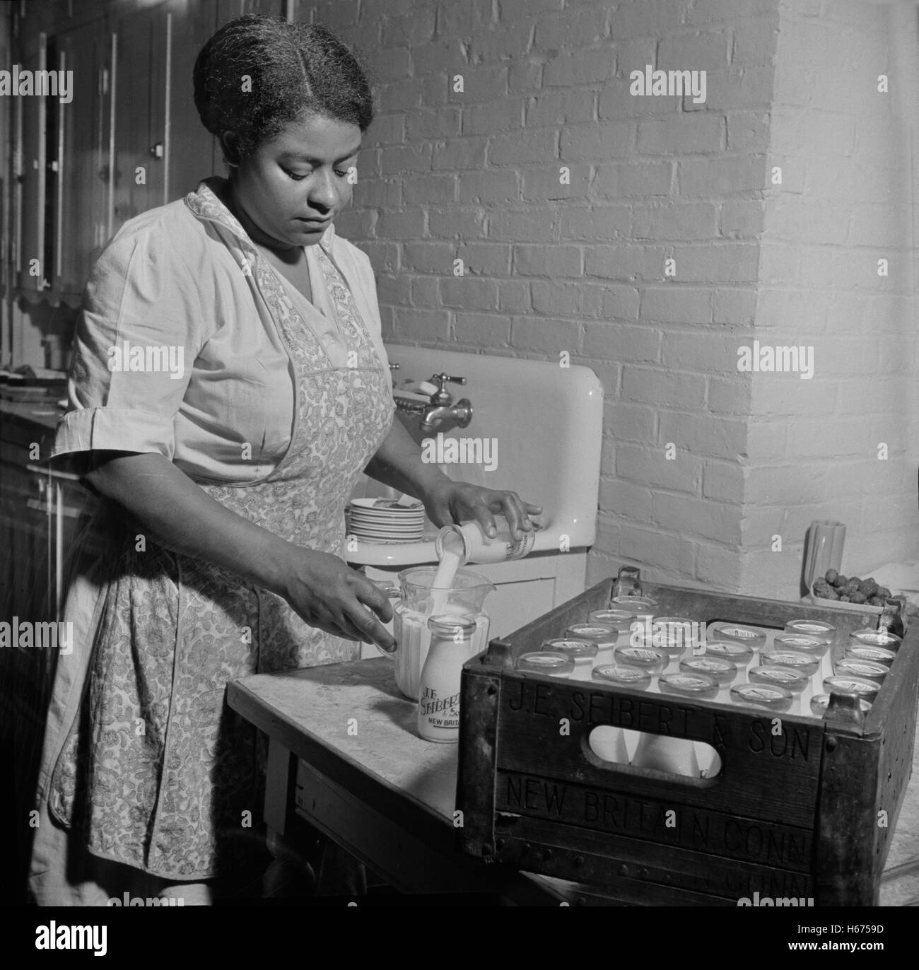 Dietician Preparing Milk for Lunch Period at Child Care Center, New Britain, Connecticut, USA, Gordon Parks for Office of War Information, June 1943 Stock Photo