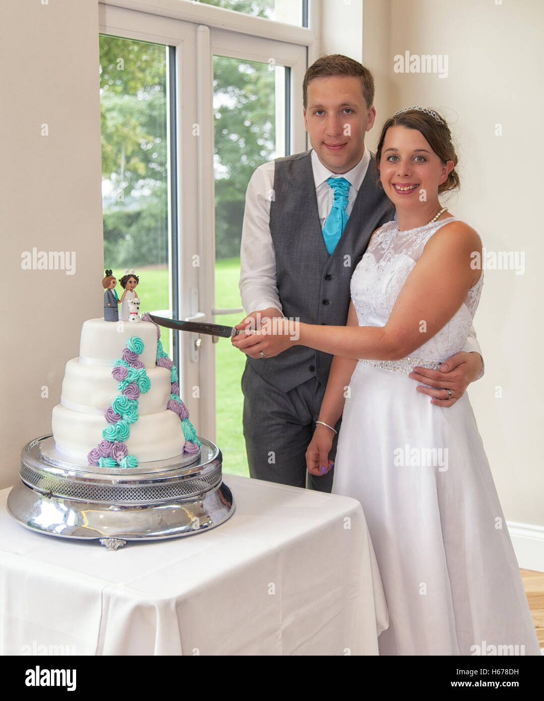 Bride and groom cutting their wedding cake on their wedding day Stock Photo