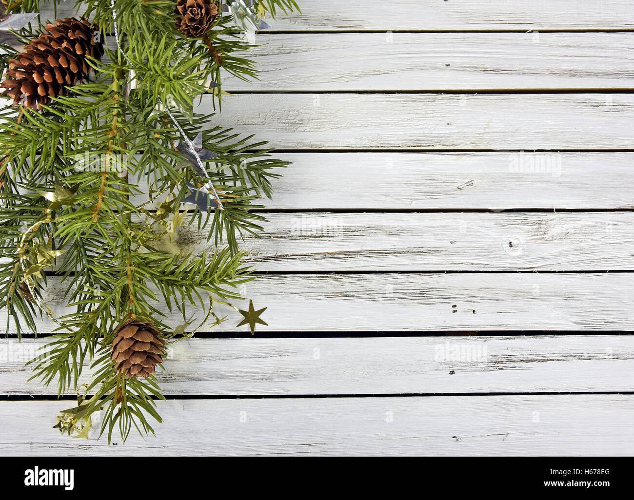 pine bough on rustic gray wood with Christmas tinsel stars Stock Photo