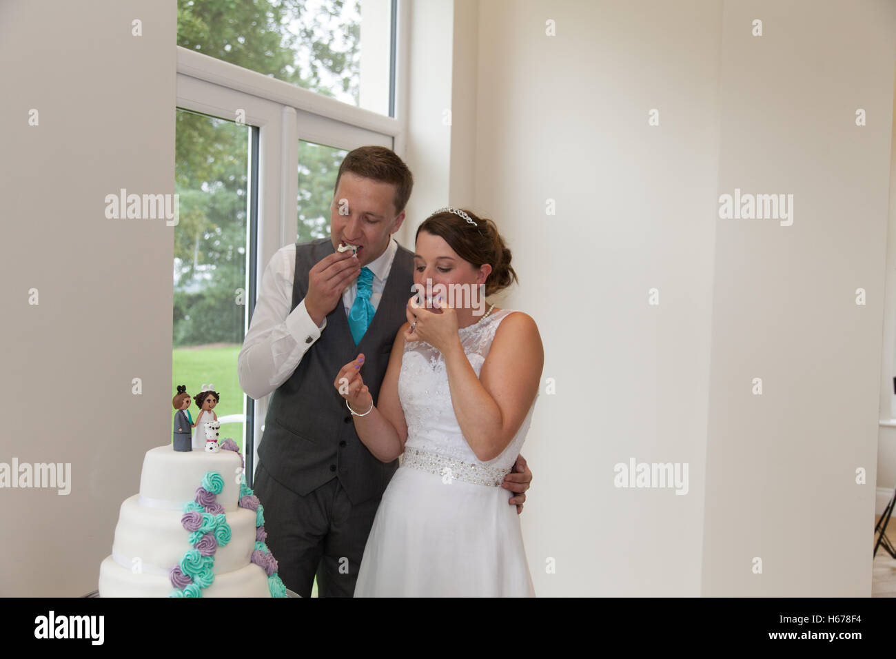 Newly weds trying out their wedding cake during the wedding reception Stock Photo