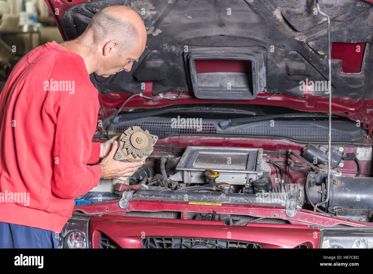 Mechanic working on a car engine in a garage Stock Photo - Alamy