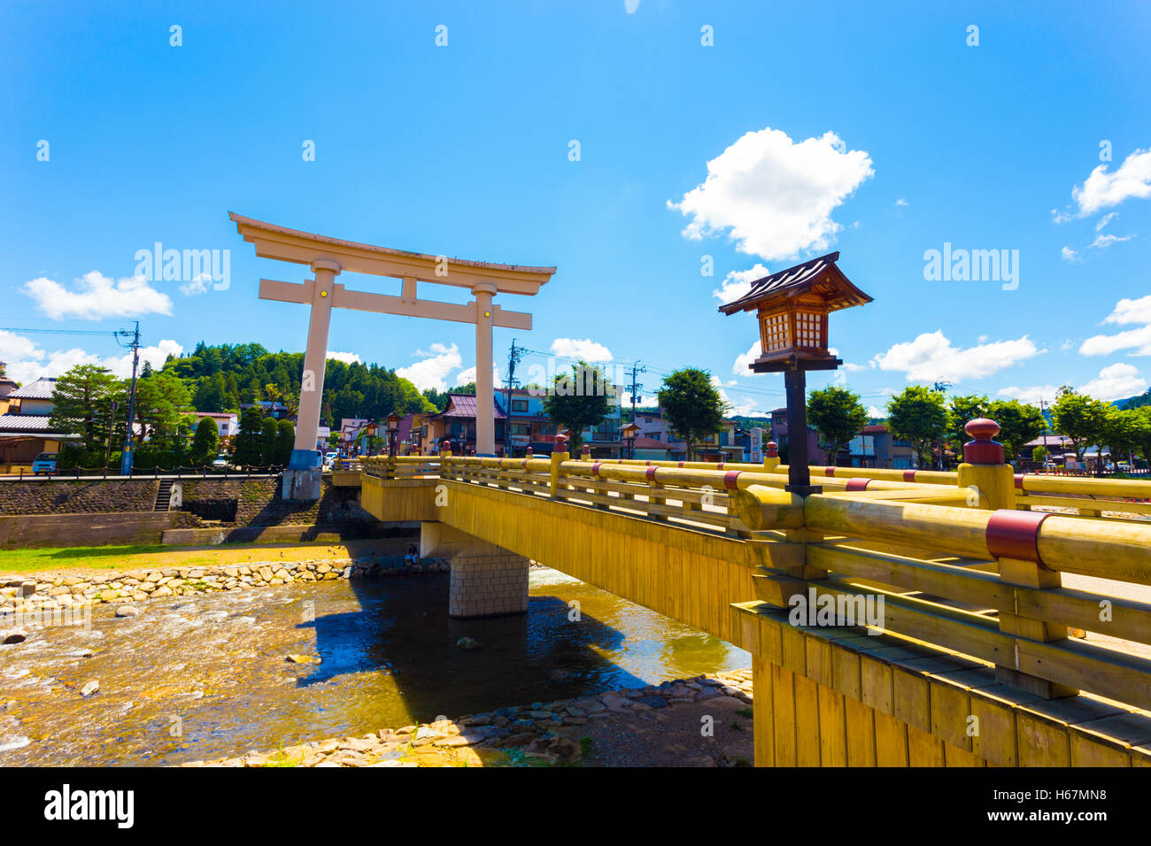 Oversized torii gate marks the entrance to the angled Miyamae-Bashi bridge over the Miya-gawa river that cuts through Takayama v Stock Photo
