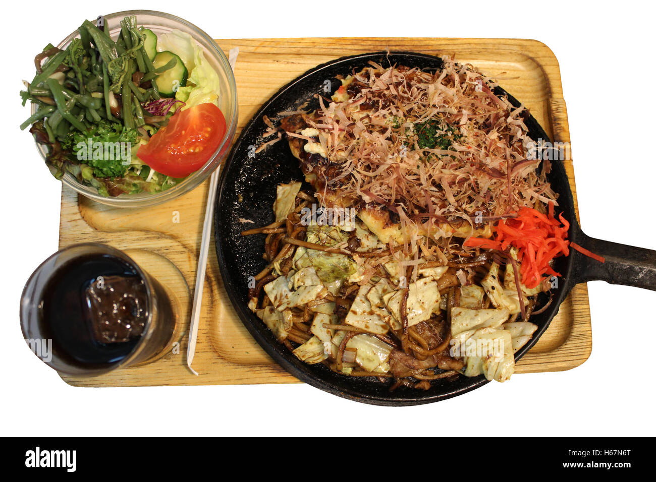 Okonomiyaki, Japanese Pizza topped with bonito flakes and sliced-pickled ginger in a hot iron frying pan in Kyoto, Japan Stock Photo