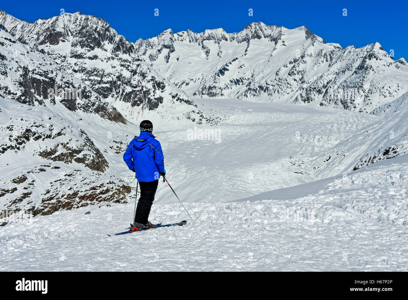 Skier looking from the viewpoint Moosfluh at the snow-covered Great Aletsch Glacier, Riederalp, Valais, Switzerland Stock Photo